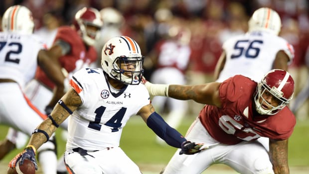 Nov 29, 2014; Tuscaloosa, AL, USA; Auburn Tigers quarterback Nick Marshall (14) scrambles chased by Alabama Crimson Tide linebacker D.J. Pettway (57) in the second quarter at Bryant-Denny Stadium. Mandatory Credit: John David Mercer-USA TODAY Sports